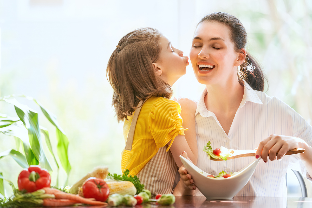 Healthy food at home. Happy family in the kitchen. Mother and child daughter are preparing the vegetables.