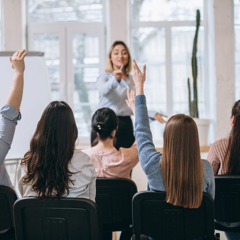 Increase. Female speaker giving presentation in hall at university workshop. Audience or conference hall. Rear view of unrecognized participants. Scientific, business event, training. Education